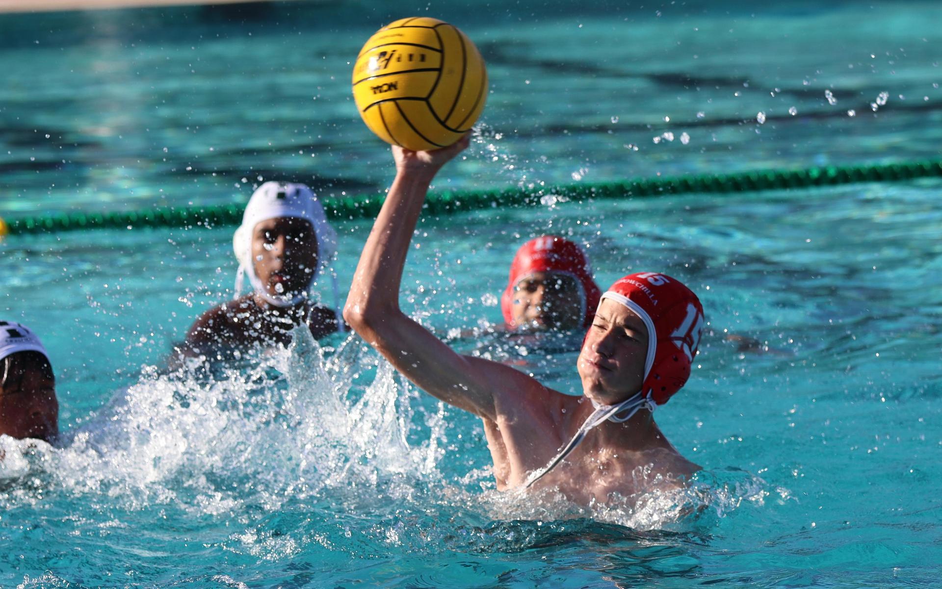 boys water polo players in action against hoover