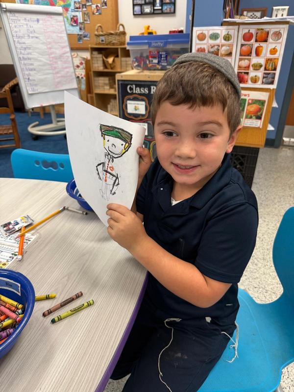 A kindergarten student works on his thank you card to veterans