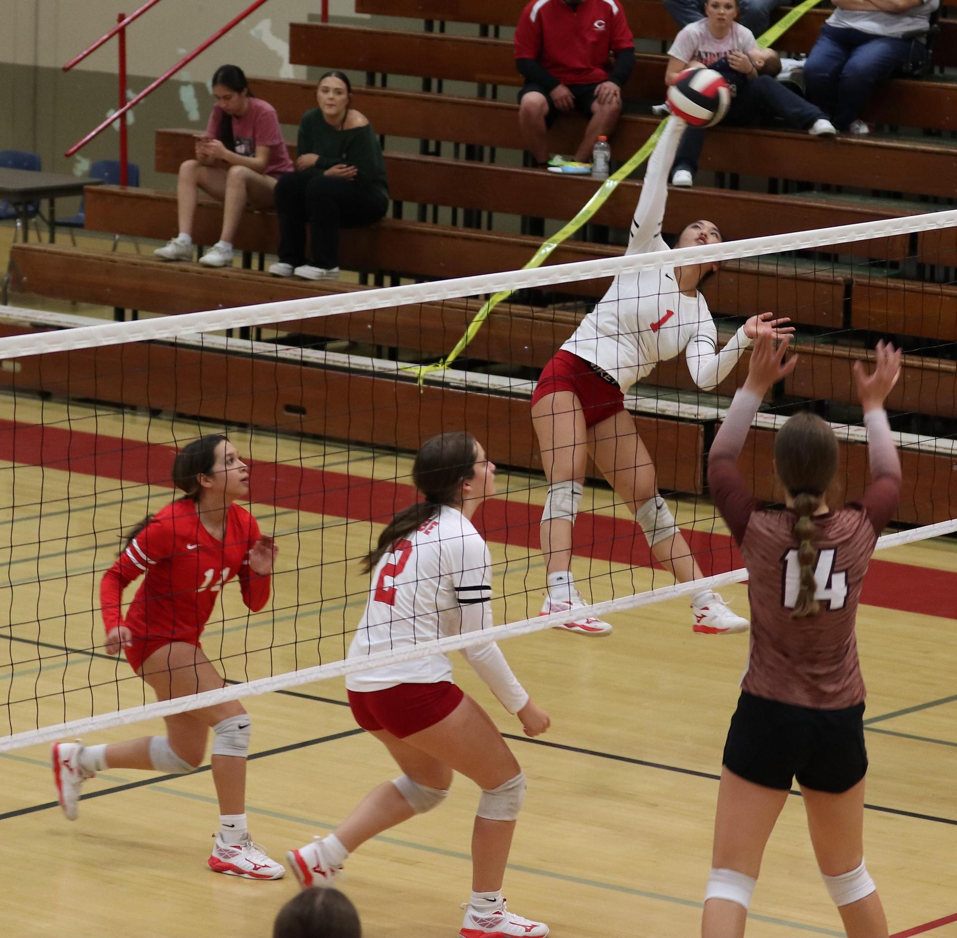 varsity volleyball players in action against Fresno Christian