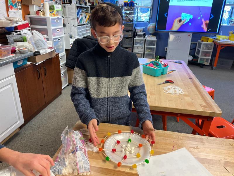 A student showing off his snowflake