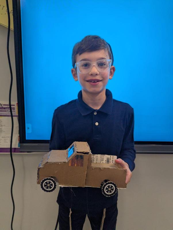 A student shows his vintage truck model that he made.