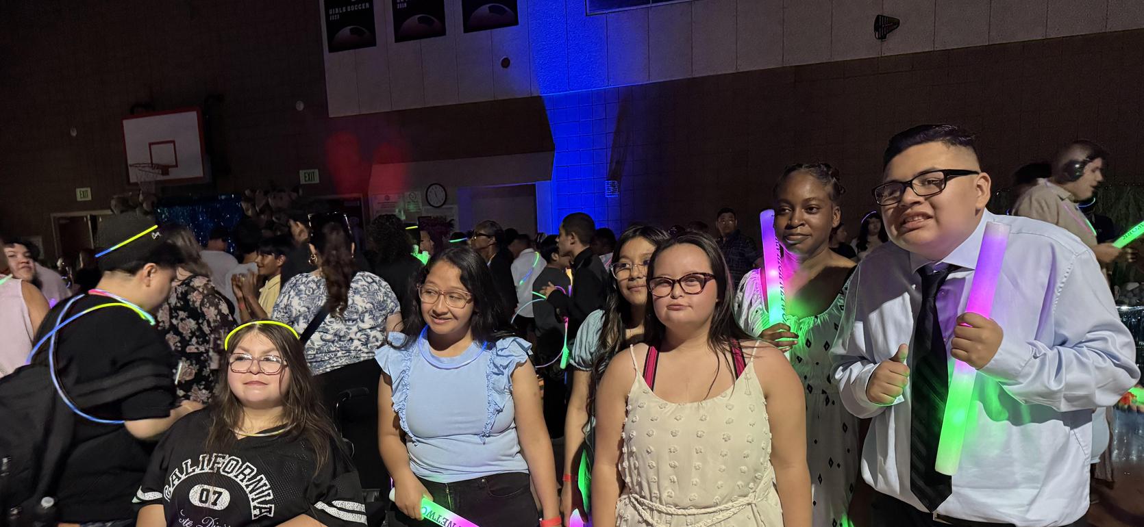A group of students holding glowing sticks at a festive event.