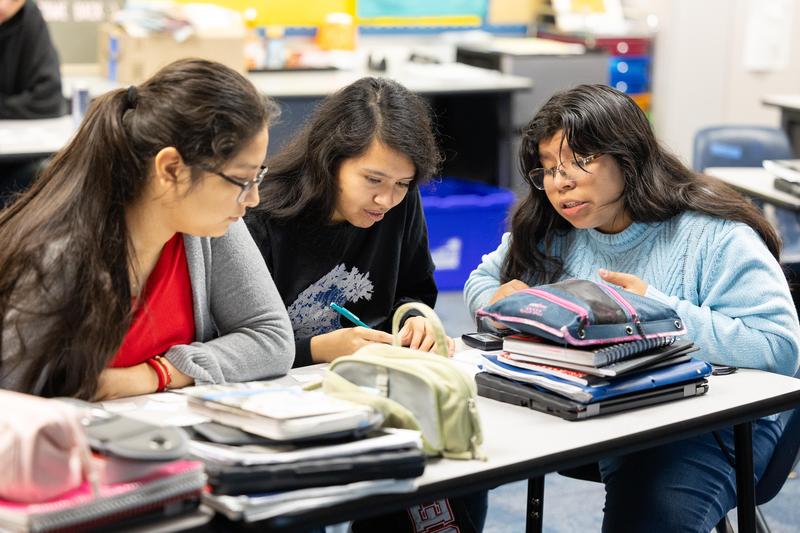 Three female Veritas students working together in class.