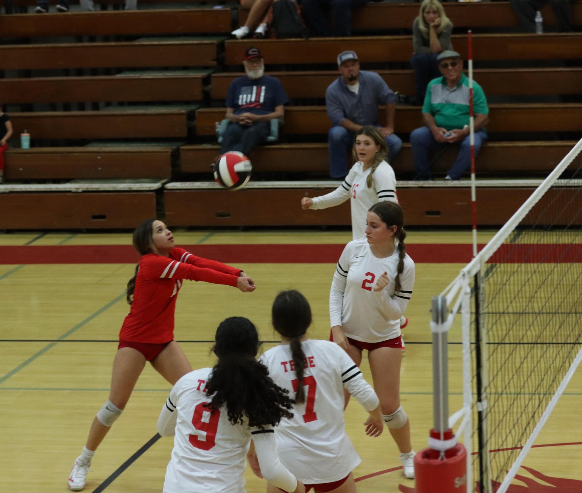 varsity volleyball players in action against liberty