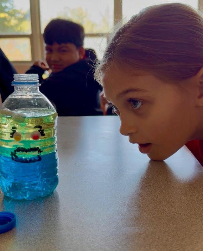 WLMS Lava Experiment Student Peering at a Bottle of Solution