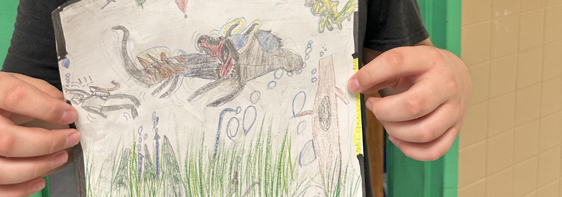 Child holding a drawing with various colorful creatures in a school setting.