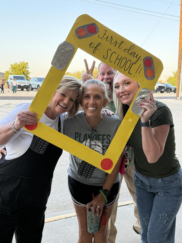 Teachers with school bus sign