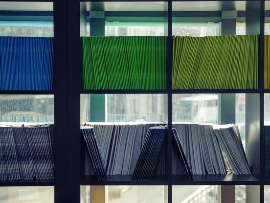 colorful books on a shelf in front a window