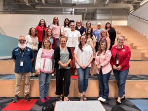 Faculty and staff stand on the risers in the Mays Library