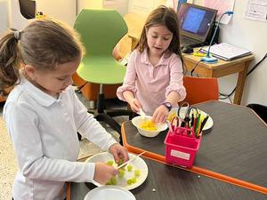 second grade girls making fruit salad.