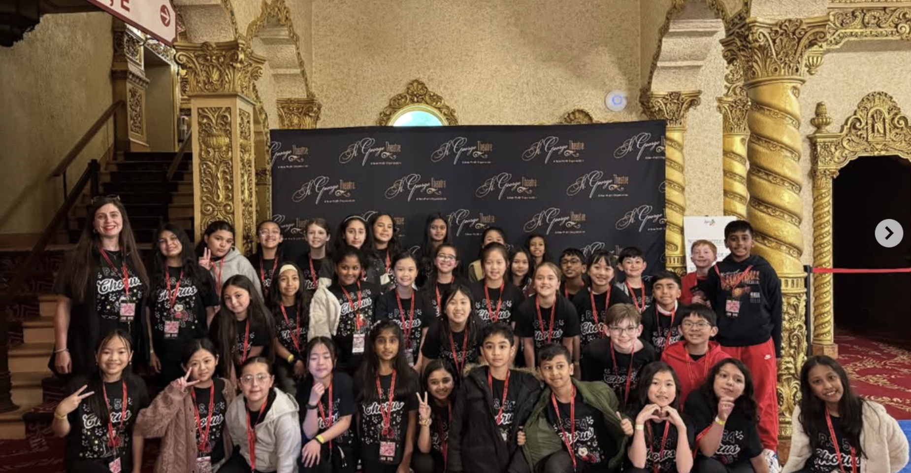 Group of children posing together in a lavish venue with a decorative background.