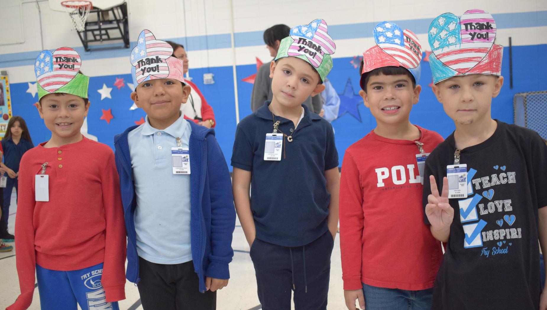 Five children wearing festive hats that say 'Thank You' with a colorful background.