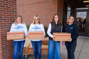 St. Clair volunteers pose for a photo while holding the food boxes