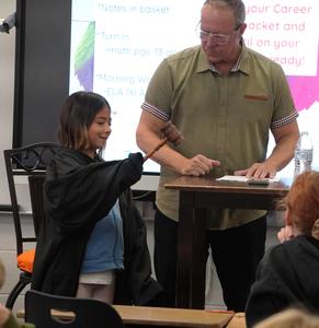Judge Mike Schipper hands over the gavel and robe to a Page student.