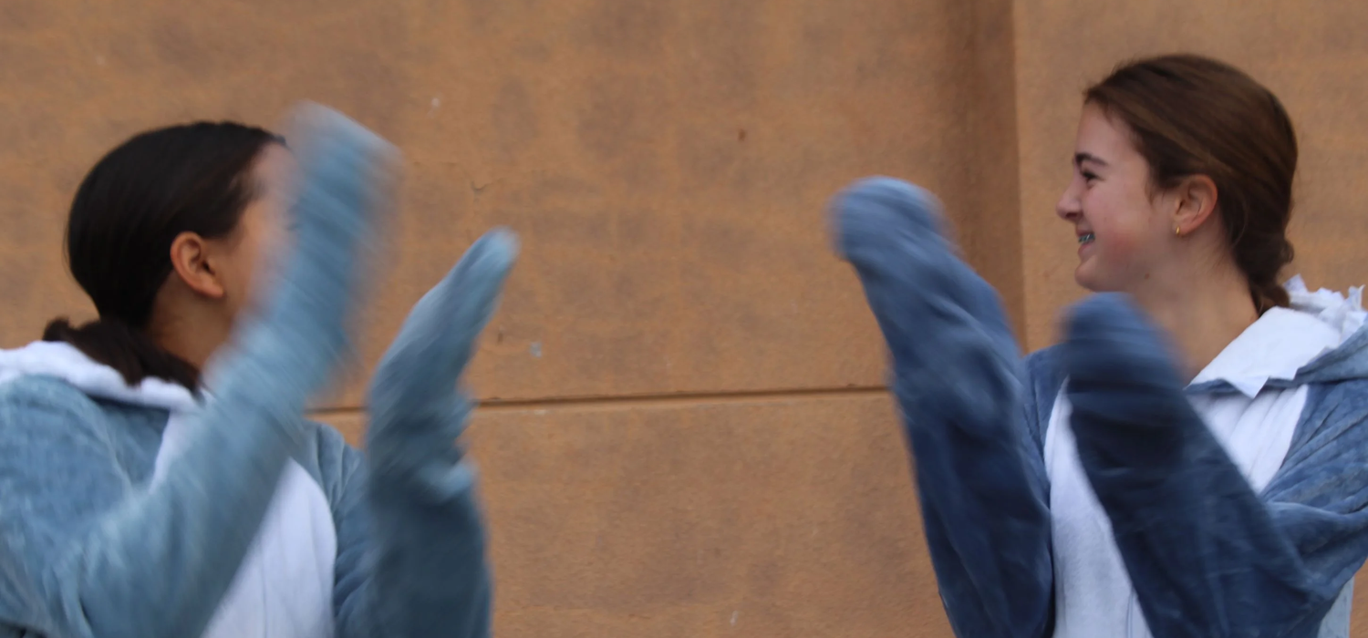Two students in shark costumes chat
