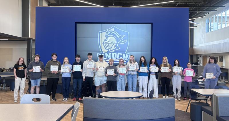 line of high schoolers holding certificates standing in front of Knoch logo