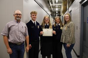 FFA students and coaches smiling for picture and holding certificate