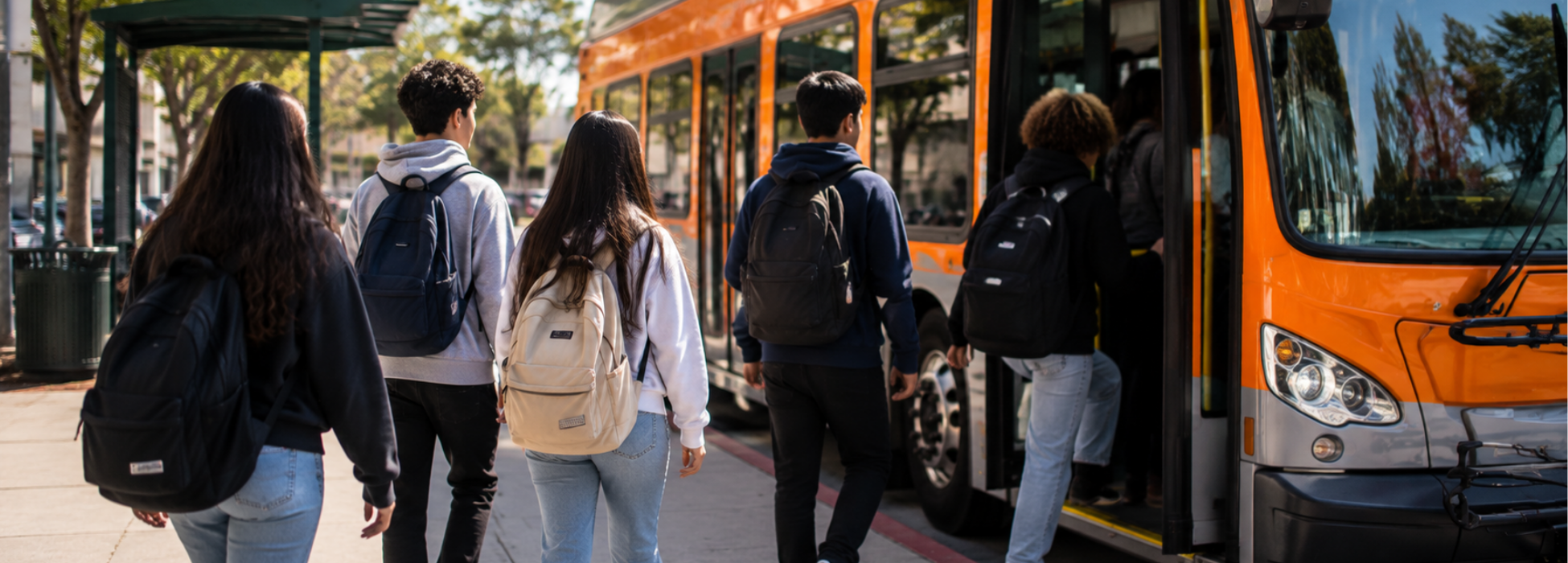 A group of students boarding an orange city bus on a sunny day.