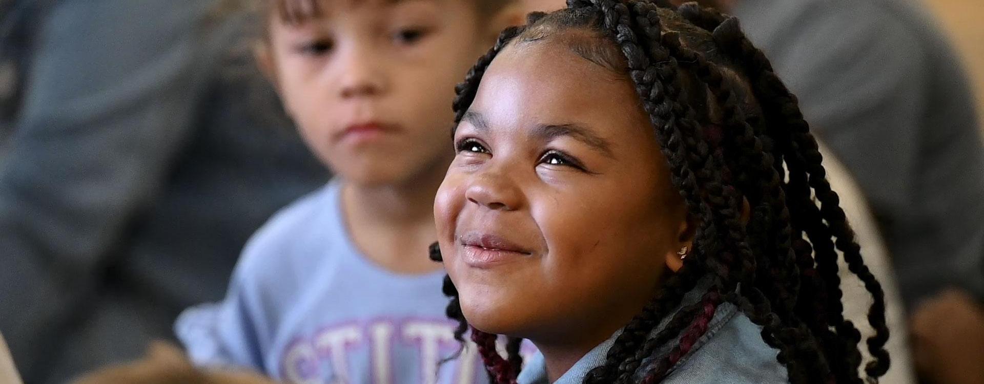 Student smiling while listening to teacher