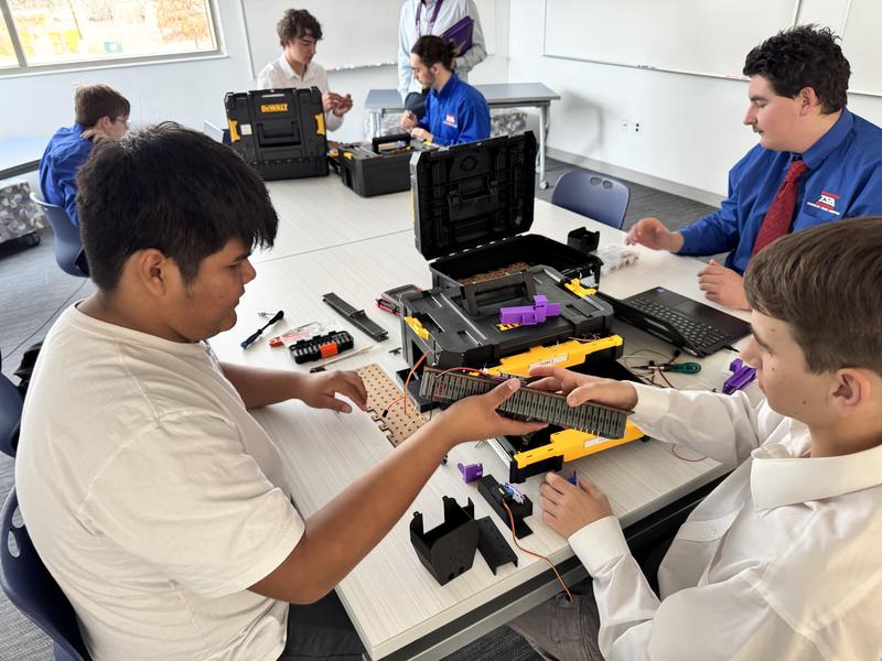 Engineering students work with robotic elements