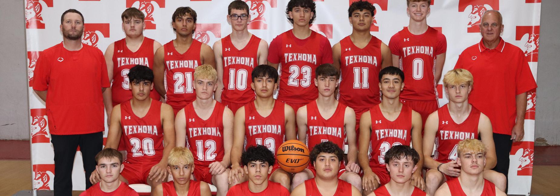 A group photo of a high school basketball team wearing red jerseys, posing with a basketball.