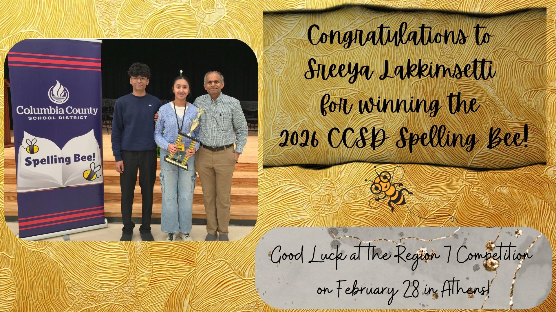 Award ceremony featuring Sreeya Lakkinsetti with her trophy, family members, and a congratulatory banner.