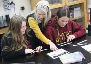 MS Science Teacher assists two students on assignment