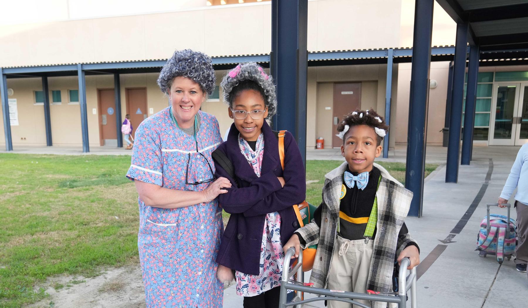 staff member and 2 students dressed up on the 100th day of school