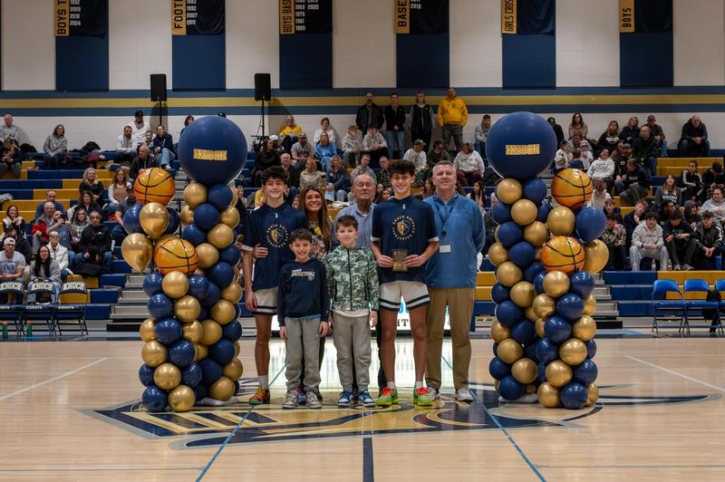 basketball player holding award surrounded by Shoop family