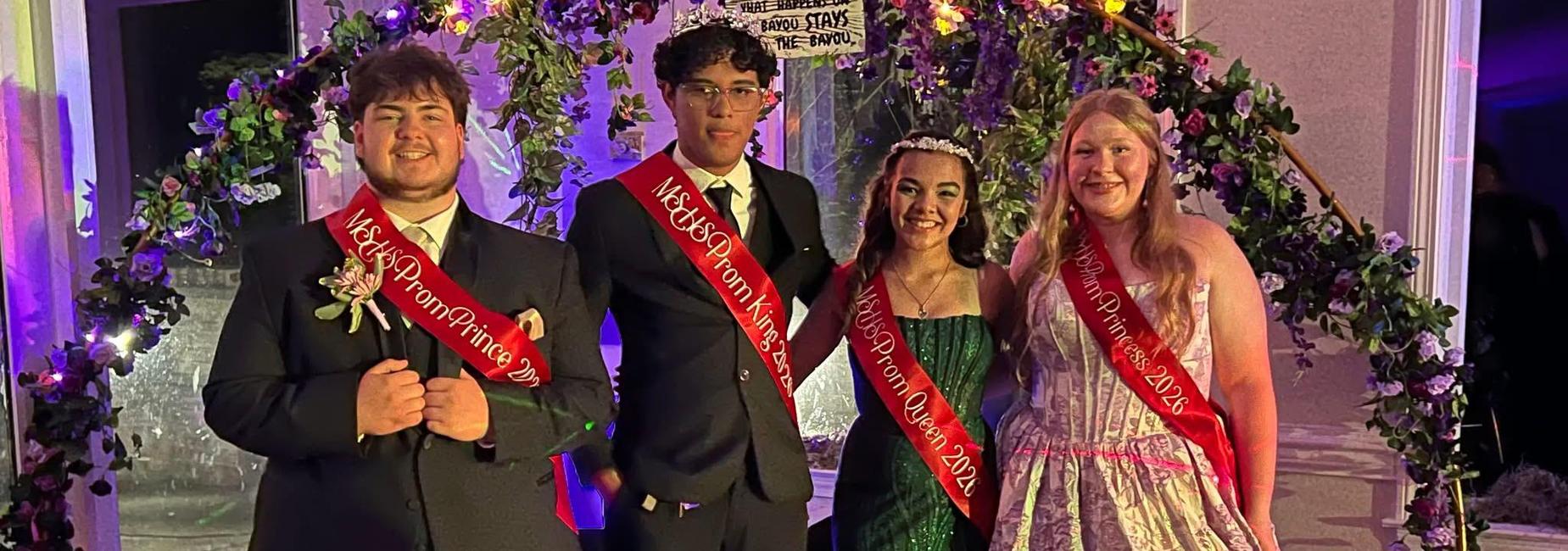 Group of students in formal wear with sashes and crowns for prom king/queen and prince/princess