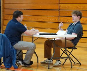 A student talks with an interviewer at the senior mock interviews.