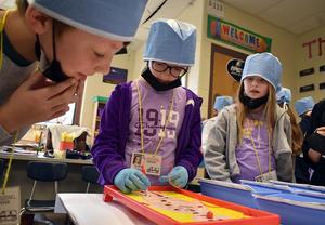 Students in surgical caps play a medical game at school.