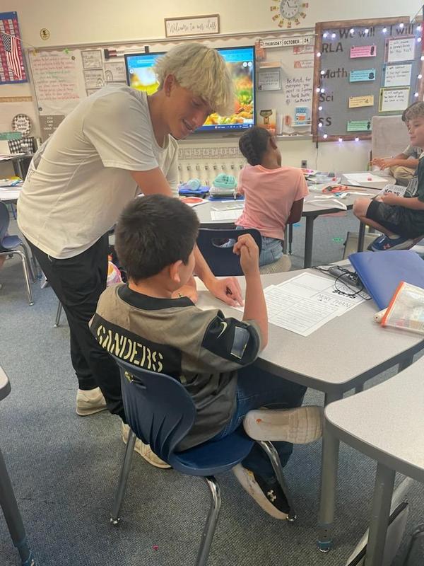 Current high school mentor with his mentee in a classroom working on a project.
