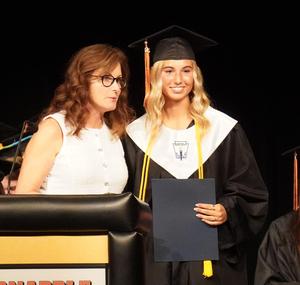 A student receives a scholarship presented by Debbie Tomko.