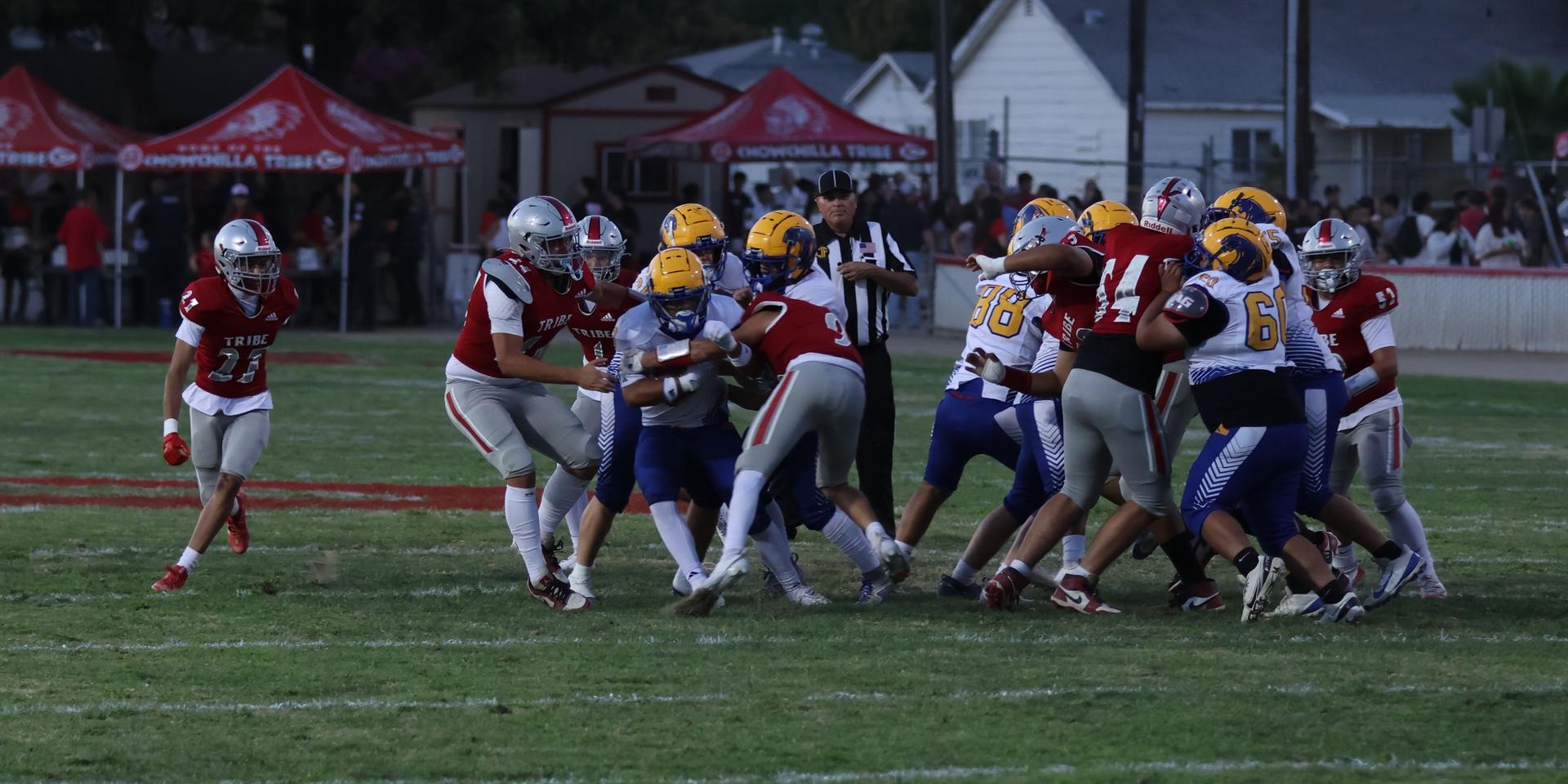 Varsity football players in action against Parlier 6