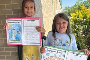 First-graders Melaina Spicciati and Kira Hayden hold their writing projects