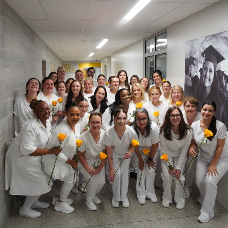 PN students together holding yellow roses