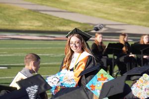 A graduate returns to her seat after introducing a guest speaker.