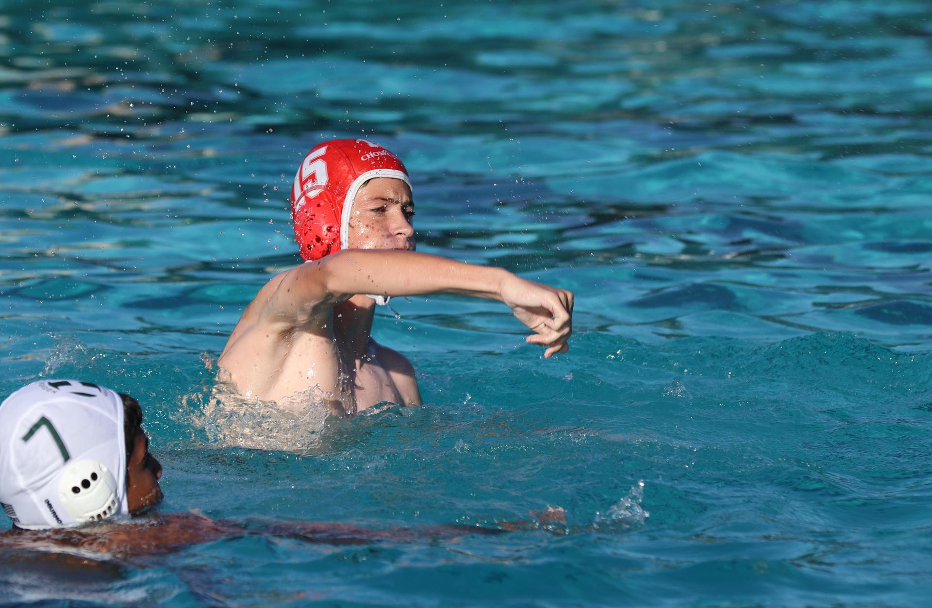 boys water polo players in action against hoover