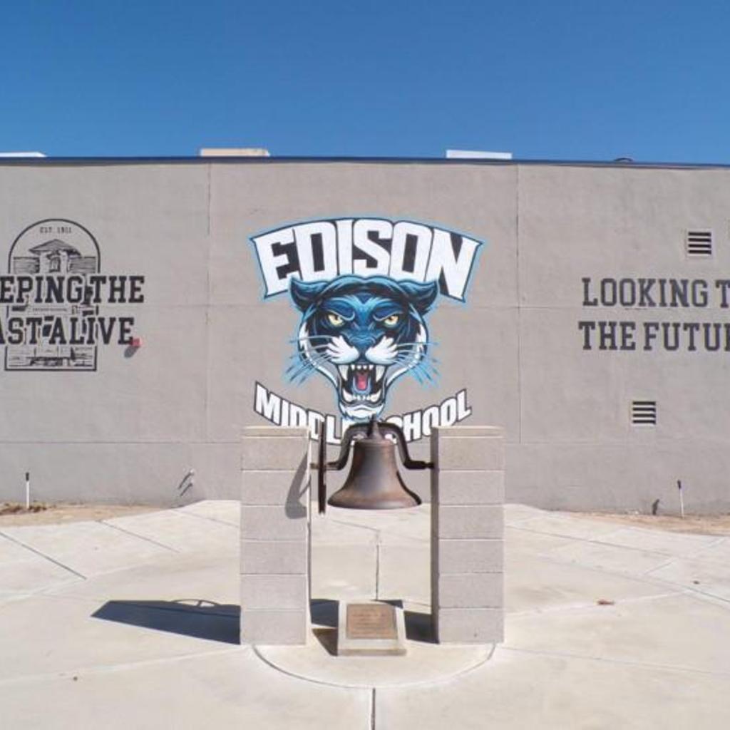 Original Edison School bell in front of Edison Middle School gym with Edison panthers logo