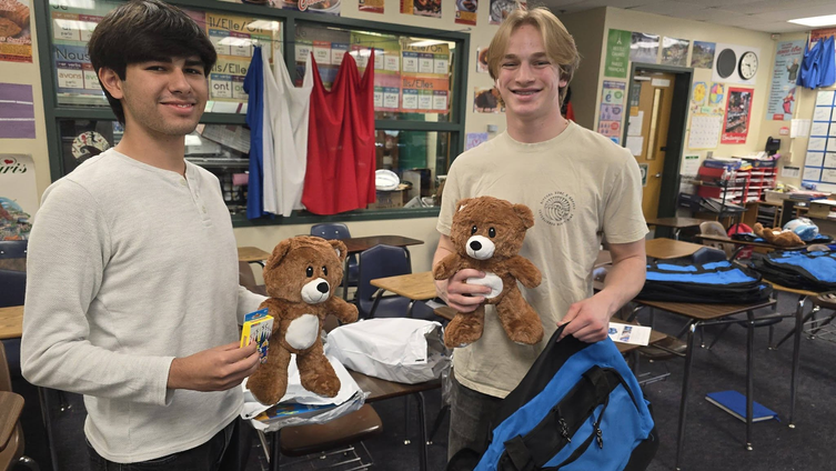 Two teenage boys holding brown teddy bears