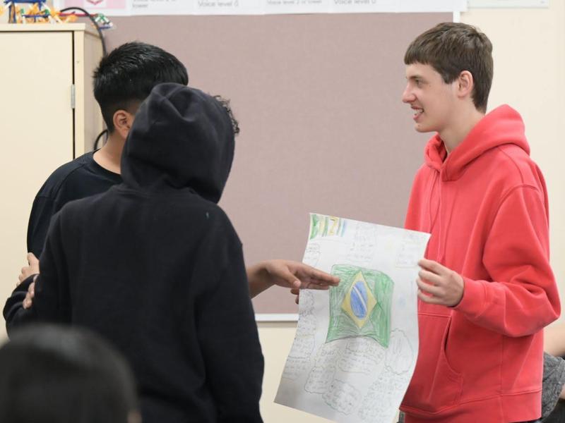Students discussing a project in a classroom setting.