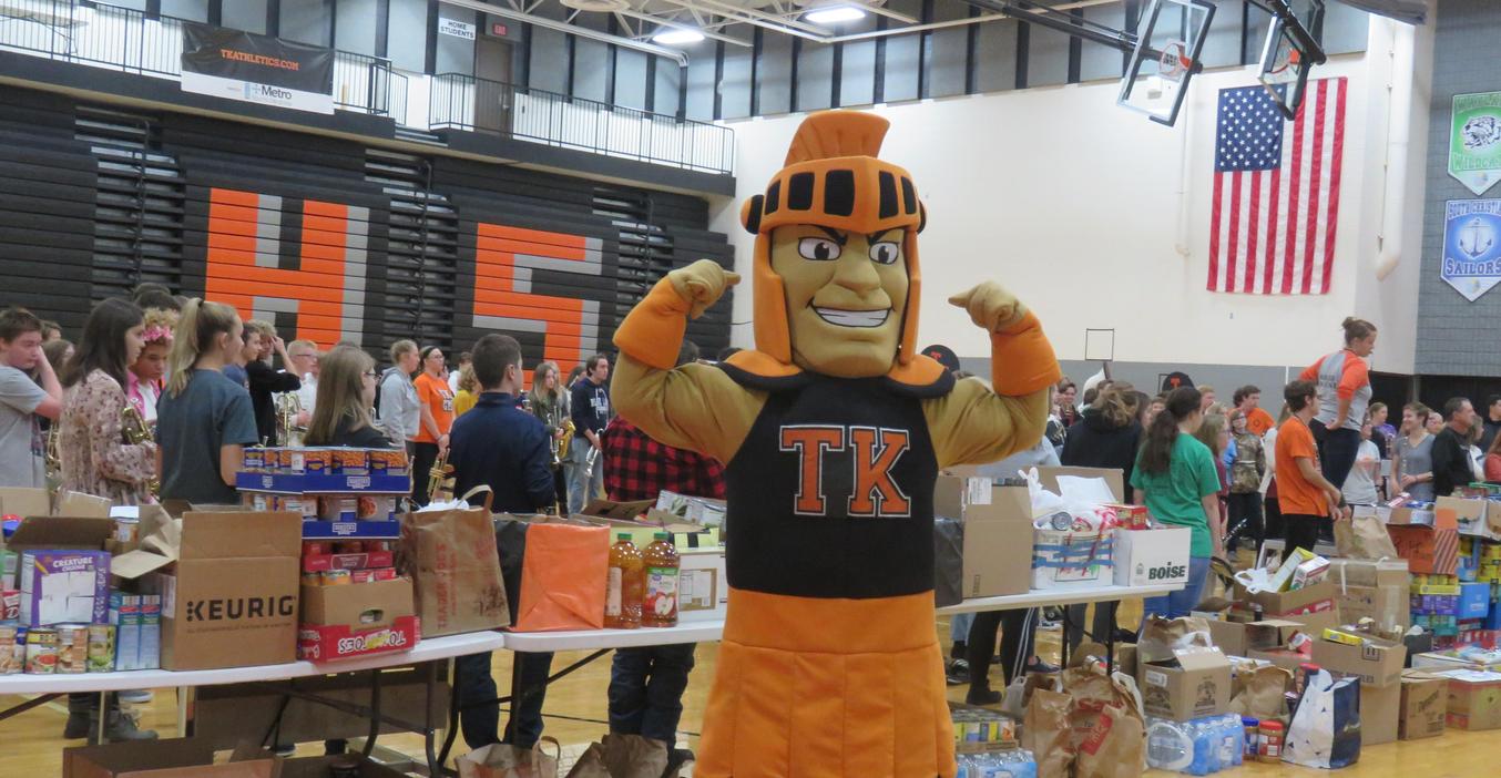 The TK Trojan flexes his muscles as students donated food items for food pantries.