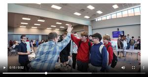 This is a thumbnail image from the attached video that captures a student high fiving an instructor