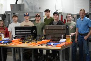 students standing behind a table with tools