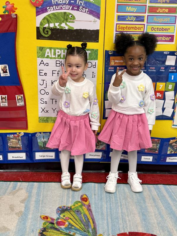 Twins in pink skirts and white tops