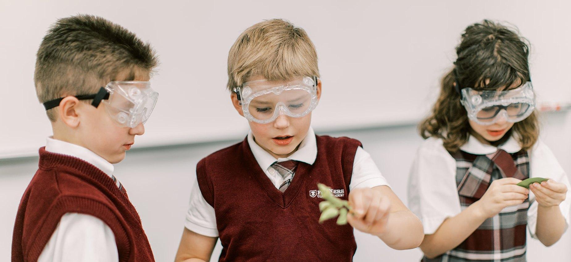 Students in safety goggles studying plants during a science lesson at El Paso Classical Academy