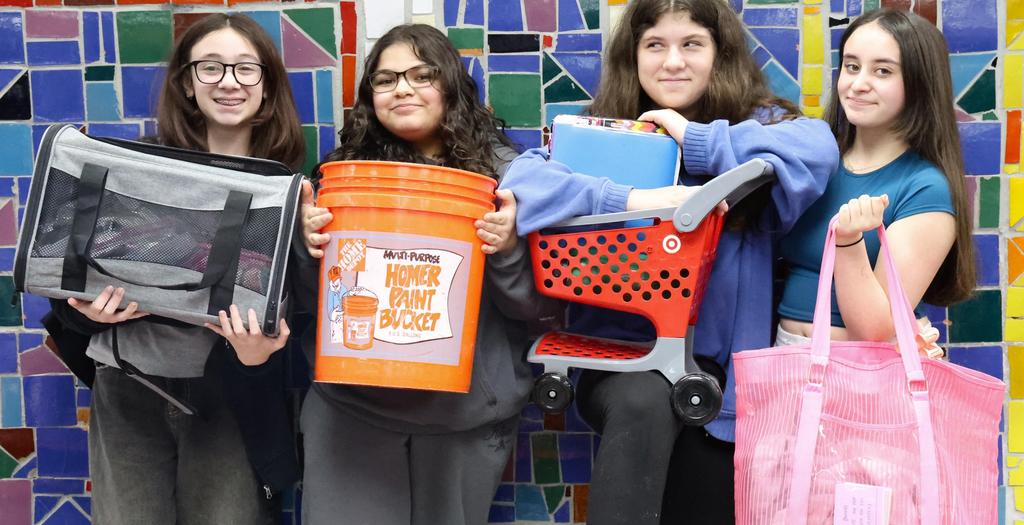 Four girls standing against a colorful tile wall.