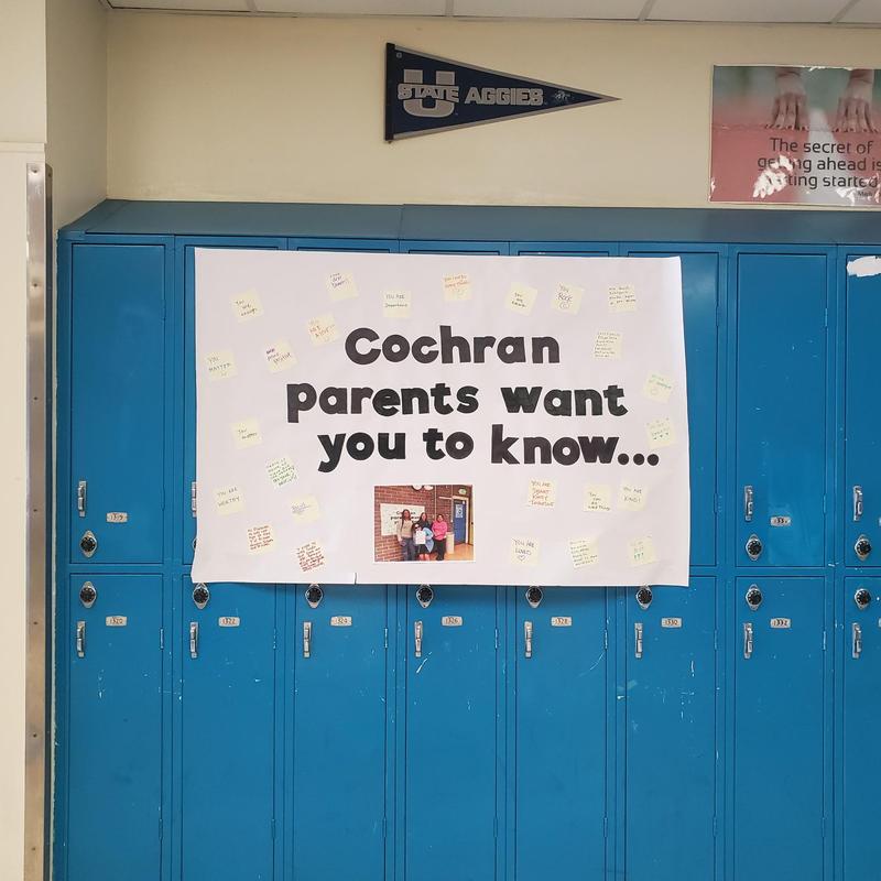 Hallway poster on blue lockers reading 