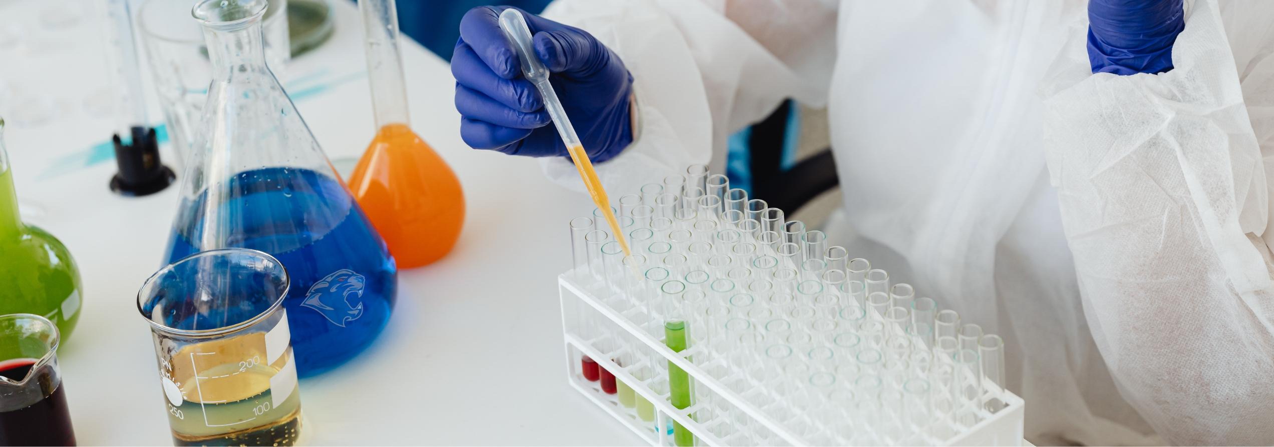 close up of hands mixing liquids in a lab